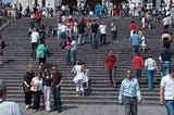 Large staircase in front of a building filling the picture with people walking up and down