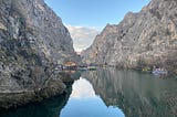 Two steep cliffs drop into a body of water below