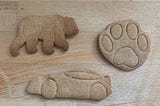 Three ginger biscuits in the shape of a bear, a paw print, and a racing car