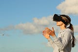 Woman using VR goggles outdoors.