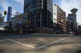 An empty intersection on a sunny day from sidewalk height