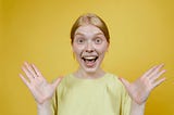 overly excited woman in front of a yellow background