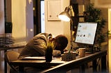 Tired drained entrepreneur sleeping on desk in startup office