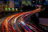 Time lapse of a busy city highway at night, the blur of headlights signifying the speed of urban life.