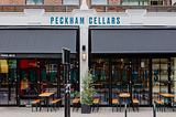 A front view of Peckham Cellars, with awnings and tables out front