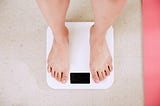 A photo of a pair of feet standing on a weighing scale.