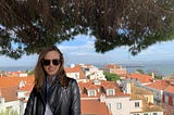 Profile picture for Megan McDonald, Product Manager at GoCardless, set in front of brick-colored rooftops and a sea view.