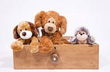 Conceptual art of three stuffed toys looking out over an opened drawer.