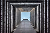 Image taken from the inside of a building looking upward at the sky where there are many floors showing on all sides