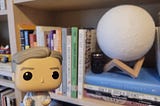 Funko Pop Bill Nye in front of a shelf of books