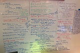 Image shows a whiteboard wall with interview notes written all over it.