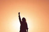 Silhouette of a person with their arm raised in a fist