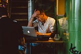 A man working on a laptop in a cafe