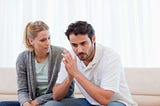 man and woman sitting on couch in deep conversation