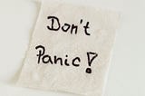 A handwritten note on a napkin, “Don’t Panic!”.