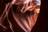 A beautiful heart shaped tunnel through terracotta coloured rock.