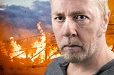 head shot of intense looking middle aged white man in front of burning bridge