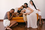Five multiethnic women lounging on a couch