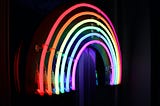 Neon rainbow arcs on black background