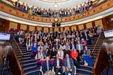 A group photo of attendees of the second International Conference on Newborn Sequencing, in a large auditorium