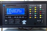 Photograph of the front panel of the Zolatron 64 computer, with multiple LEDs and an LCD screen displaying the messages: ‘SPI interface’; ‘Extended Memory’; ‘No parallel I/F’; and ‘Ready’.