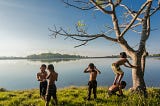 Five boys playing near a body of water