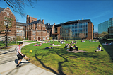 Students socialize on a college campus in sunny weather