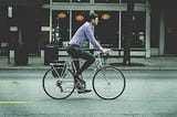 Man riding vintage bike down the city street.