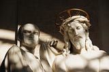 Marble carving of Pontius Pilate standing next to Jesus with his crown of thorns and a halo.