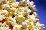 Why do people prefer eating popcorn while watching cinema?