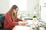 Woman is sitting on the keyboard and working on something important