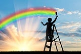 Child on ladder painting a rainbow before a bright sunrise