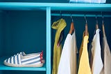 Clothing hanging neatly in a closet.