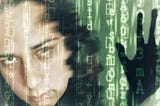 A slightly blurred face of an insanely beautiful light-skinned autistic transgender woman, superimposed with vertical green lines of code on a dark background. Beside her, to the right, is thesilhouette of a hand,pressing against the code as if it were a barrier it sought to escape.