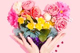 A female holding flowers’ bouquet with her two hands.