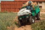 A man riding an ATV through a farmland