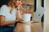 Woman working on laptop in coffee shop