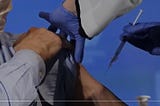 Man taking a vaccine on left arm