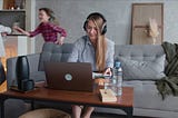 Woman works from home as kids play in the background