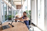 A man working out with a handcycle following a Kakana workout from his computer.