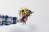 Image of someone holding out flowers.