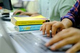 design books at a computer desk