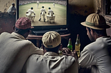 A group of friends watching cricket.