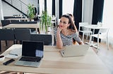 young attractive woman is sitting at the table planning to form a company