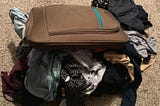 Suitcase with clothing falling out