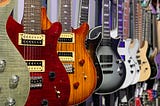 Assorted-color electric guitars hanging on a wall