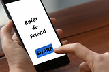 A mobile user about to click on the share button of a Refer-A-Friend campaign.