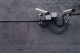 Two bullet surveillance cameras attached on wall