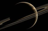The planet Saturn with its rings in the dark sky.