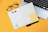 Image of laptop with to do list notebook.